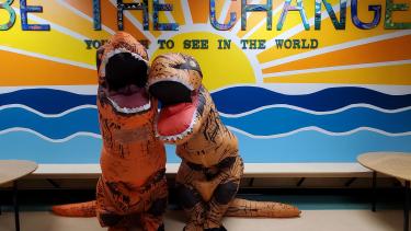 Two students in blowup dinosaur costumes. 