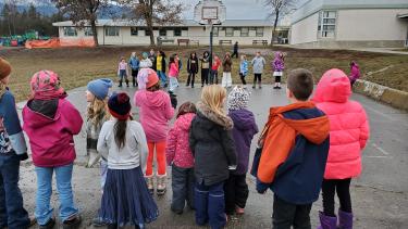 approximately 30 students outside at recess playing a game of Beaver Sam