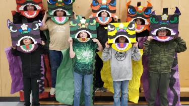8 students posing for a picture wearing their lion costumes for lunar new year dance