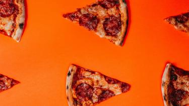 Pepperoni pizza slices against an orange background