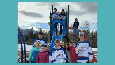 A group of young children and teens in front of and on a playground slide