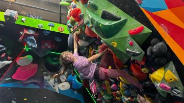 Student climbing on an indoor rockwall