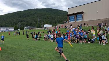 students running relay race, many other students watching