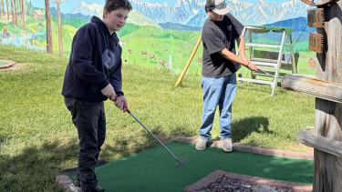 two students playing mini-golf