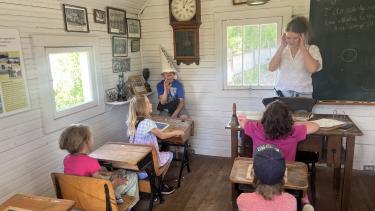 students at the museum in a one room school house