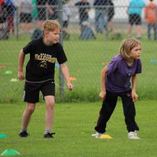Two children on the starting line of a sports day in a grassy field